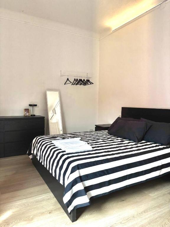 a bedroom with a black and white striped bed at Milano side house apartment in Sesto San Giovanni