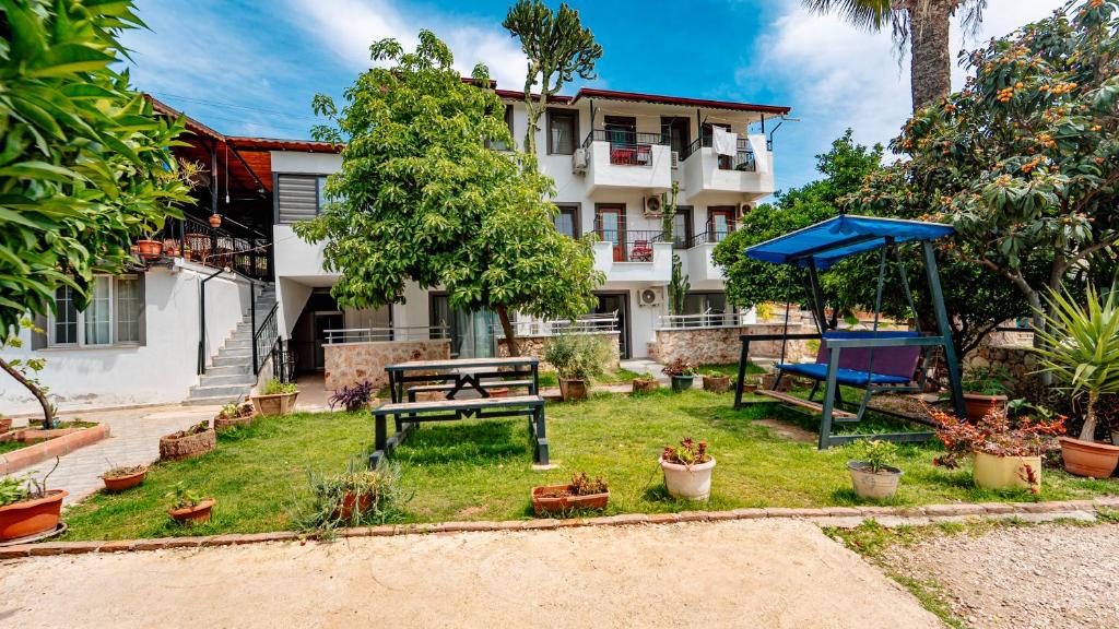 a garden with a picnic table and a bench in front of a building at Flower Hotel Patara in Patara