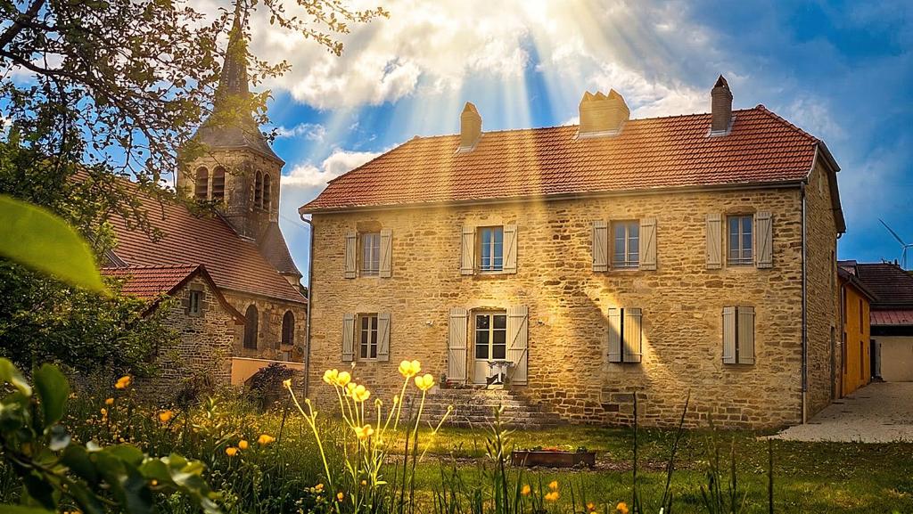 an old brick building with a tower and a church at La Valdonnière in Esnoms-au-Val
