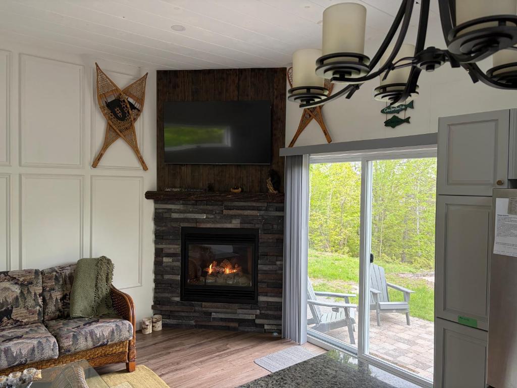 a living room with a fireplace and a tv at Hidden Getaway in Pembroke