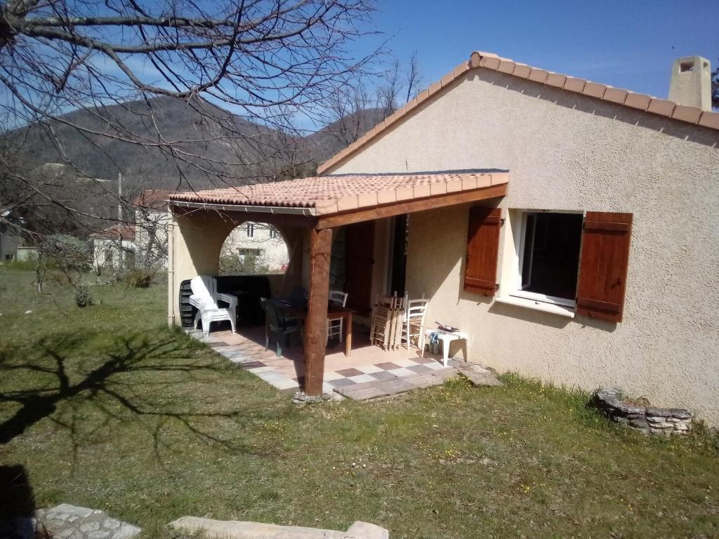 a house with a porch with a table and chairs at Chambre à louer dans villa ou Location maison entière in Montjoux