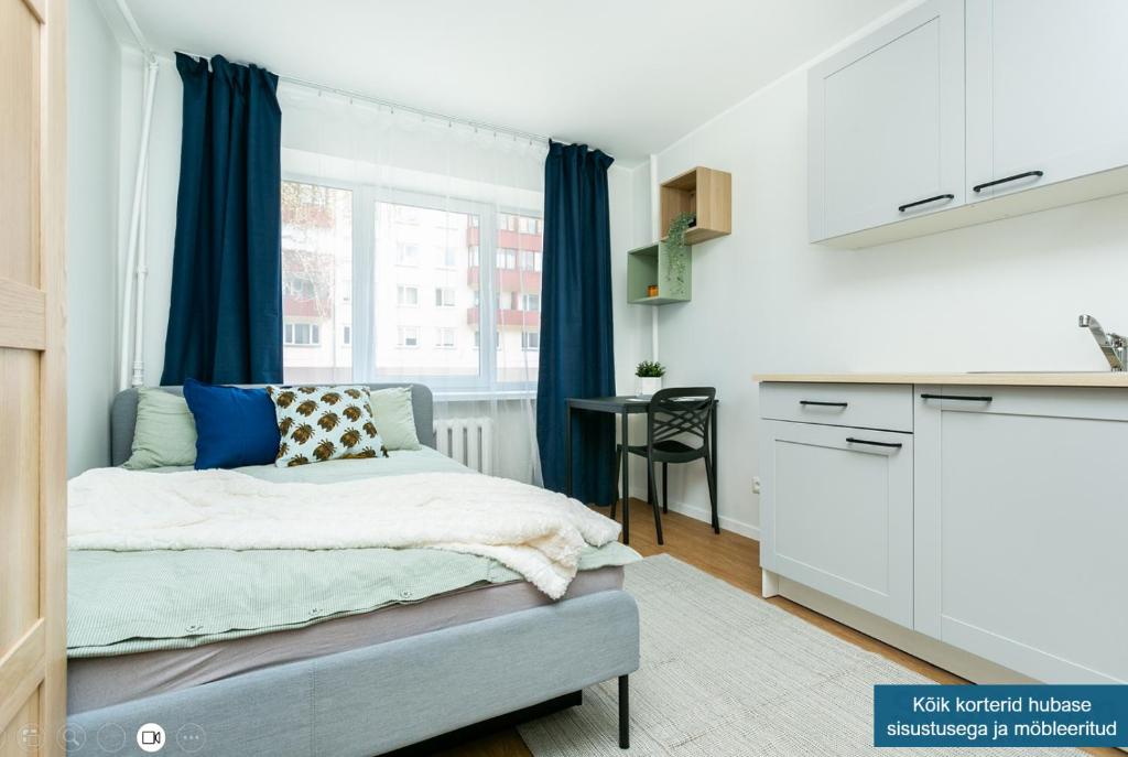 a small bedroom with a bed and a kitchen at Sõle Studios by RevalHome in Tallinn