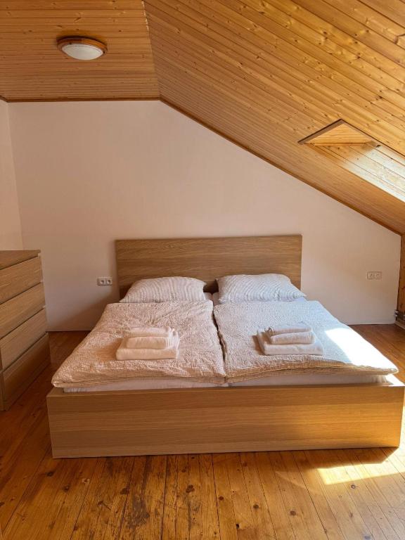 a bed in a bedroom with a wooden ceiling at Apartment sklep 33E in Hrušky