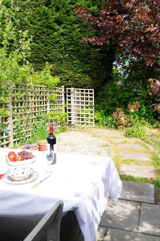 a table with a bottle of wine and a plate of food at Self-contained flat in Girton