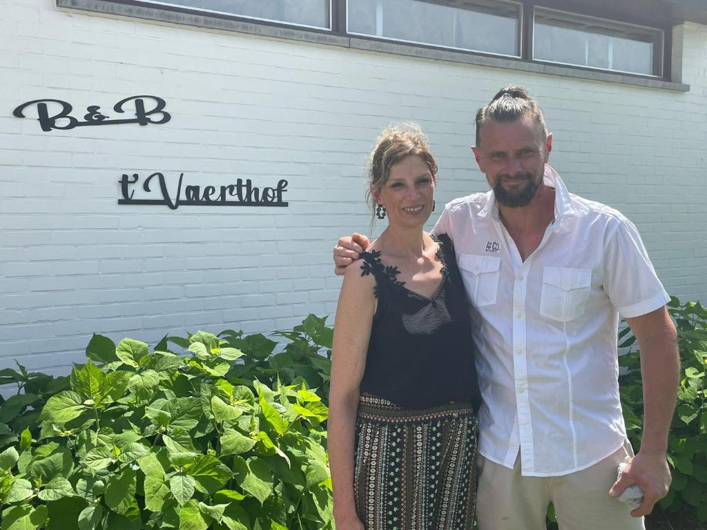 a man and a woman standing in front of a building at Vaerthof in Diepenbeek