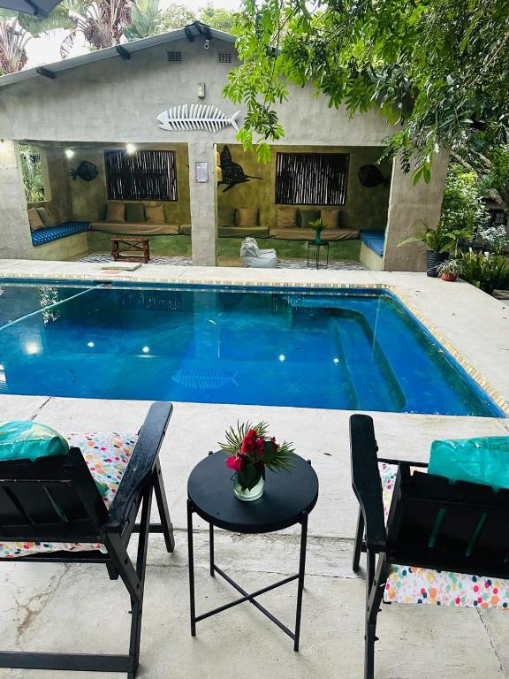 a swimming pool with two chairs and a table next to it at Emoyeni Eco Lodge in Sodwana Bay