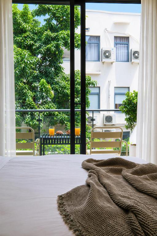 a bedroom with a bed and a large window at Centraltique Veranda Living in Hanoi