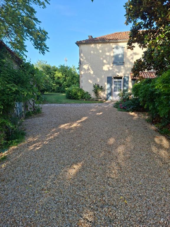 a gravel driveway in front of a house at La Glycine, Maison au calme avec jardin, Fibre Wi-Fi, 20 min des plages, Parking privé in Luçon