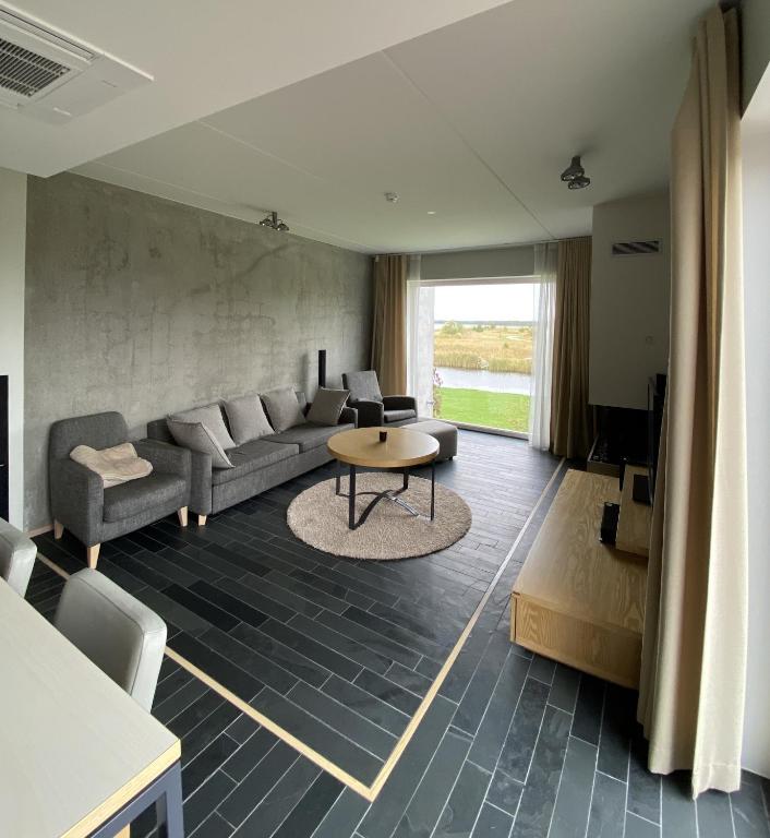 a living room with a couch and a table at Stylish Sea-View Apartment by the Marina in Kuressaare