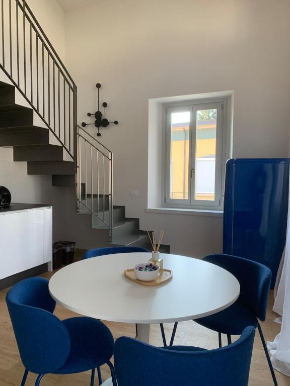 a dining room with a white table and blue chairs at Spazio Perlasca Apt 4 - Cernobbio Como Lake in Cernobbio