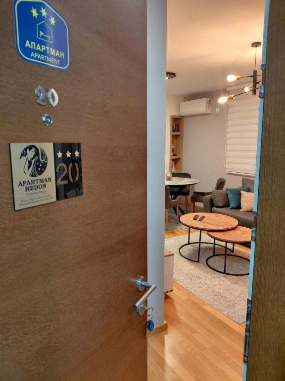 a door leading into a living room with a table at Apartman Hedon in Vrnjačka Banja