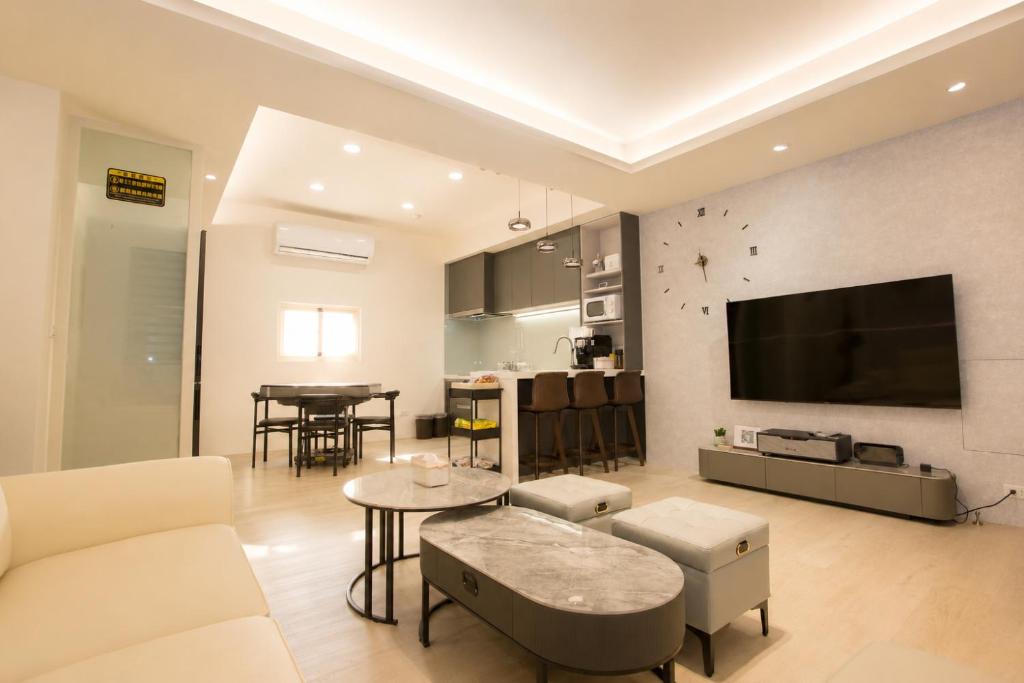 a living room with a couch and a tv on a wall at T and C 民宿 in Wujie