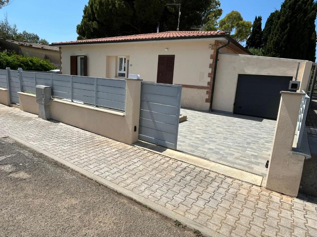 a house with a fence and a garage at Casa Fellini - Giardino e parcheggio gratuito in Venturina Terme