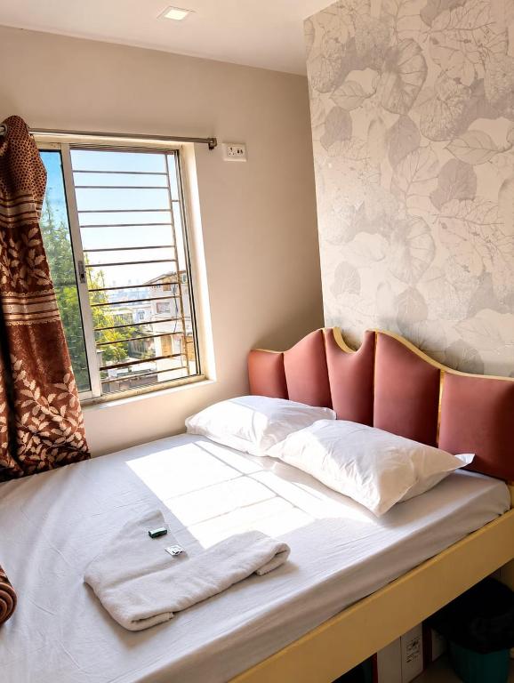 a bedroom with a bed with a towel on it at Saba Guest House in Kolkata