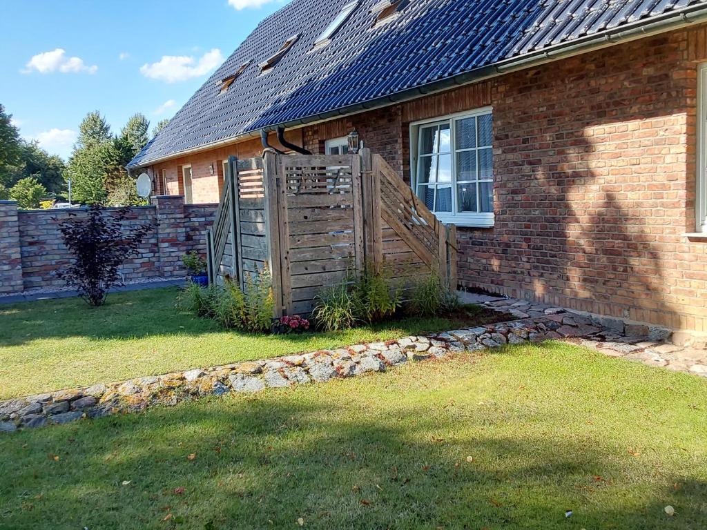 a brick house with a wooden gate in the yard at Ferienwohnung Paula, Kluis in Gagern