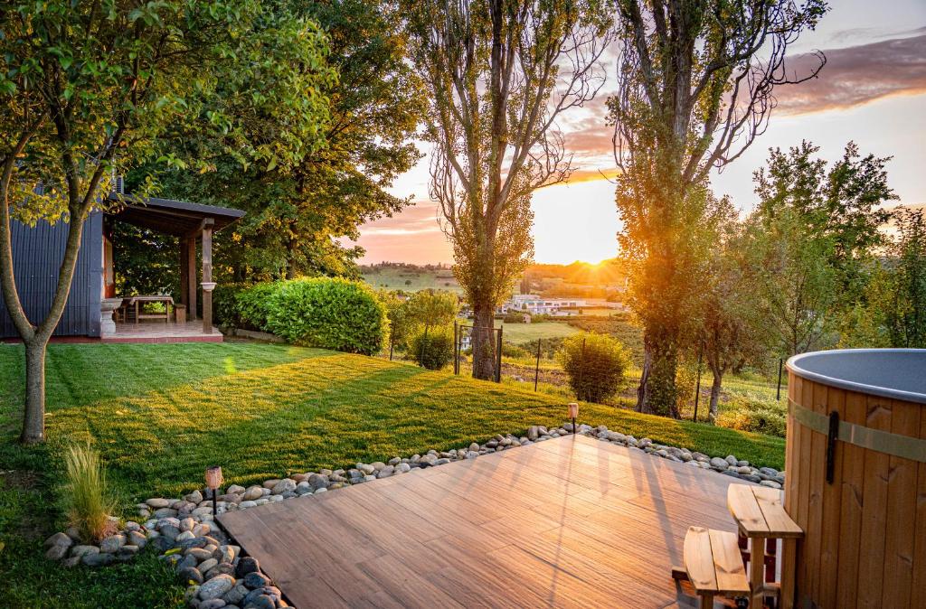 a backyard with a wooden deck and a lawn at Il Casotto tra i Vigneti in Nizza Monferrato