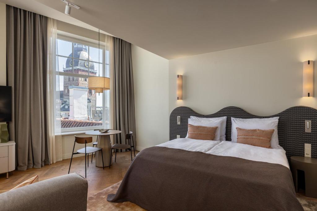 a hotel room with a bed and a window at Carillon Aparthotel - Keystone Collection, opened December 2025 in Riga