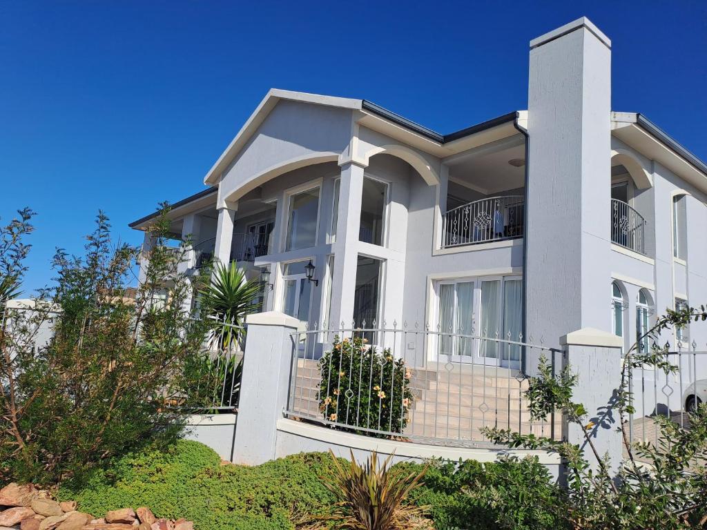a large white house with a fence at Stone Crown Manor B&B in Mossel Bay