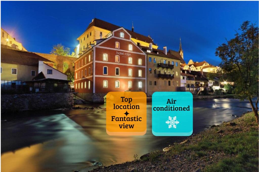 a group of buildings next to a river at LH Hotel Mlýn in Český Krumlov