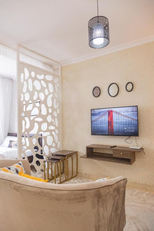 a living room with a couch and a tv at Modern Airport Studio apartment 5 mins to JKIA &SGR,Fast Wi-Fi,Ideal for layovers and longstays in Nairobi