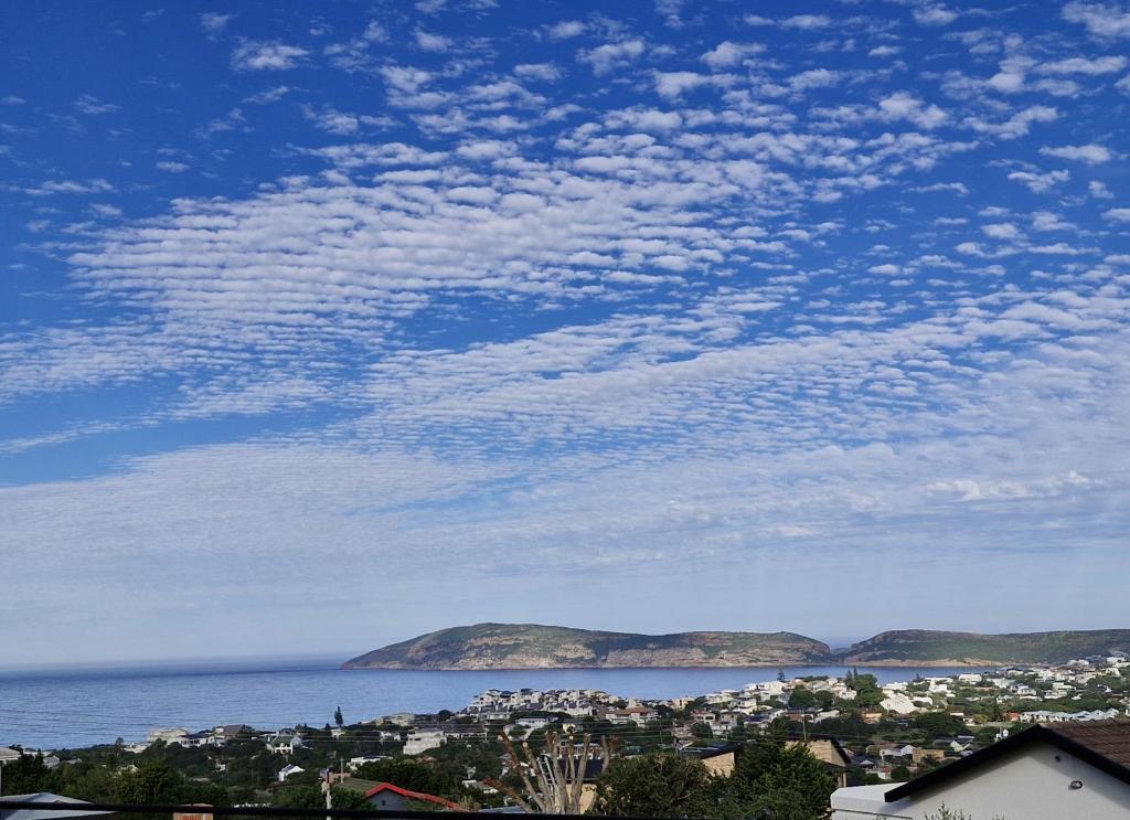 a view of a city and the ocean with mountains at A Time And A Place in Plettenberg Bay