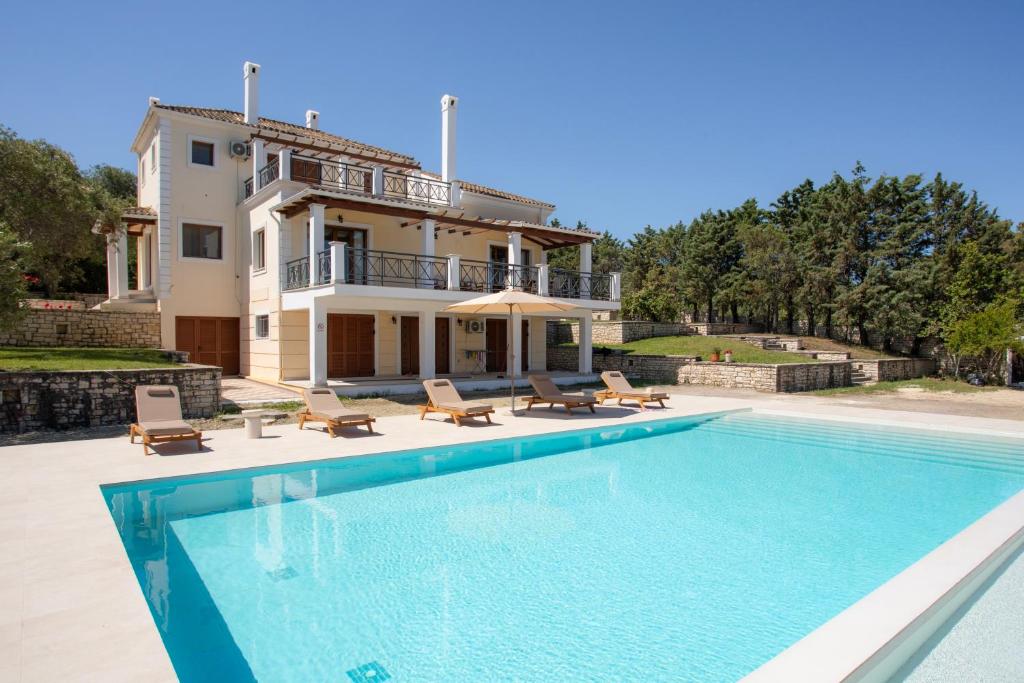 a villa with a swimming pool in front of a house at Utopia Beach Villa in (( Litherés ))