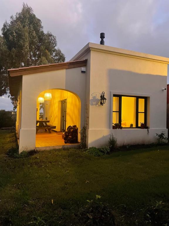 a small white house with a table in front of it at Casita colonial en Chapadmalal in Chapadmalal