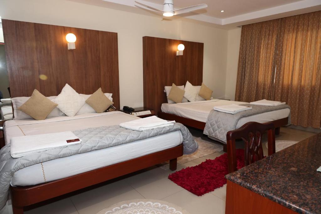 a hotel room with two beds and a counter at Dhanunjayas Luxury Hotel in Hosūr