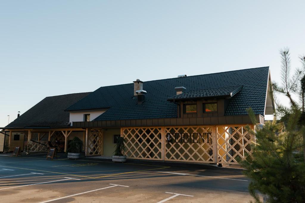 a building with a black roof and a parking lot at Hiša S'TJE Ljubljana Airport in Cerklje na Gorenjskem