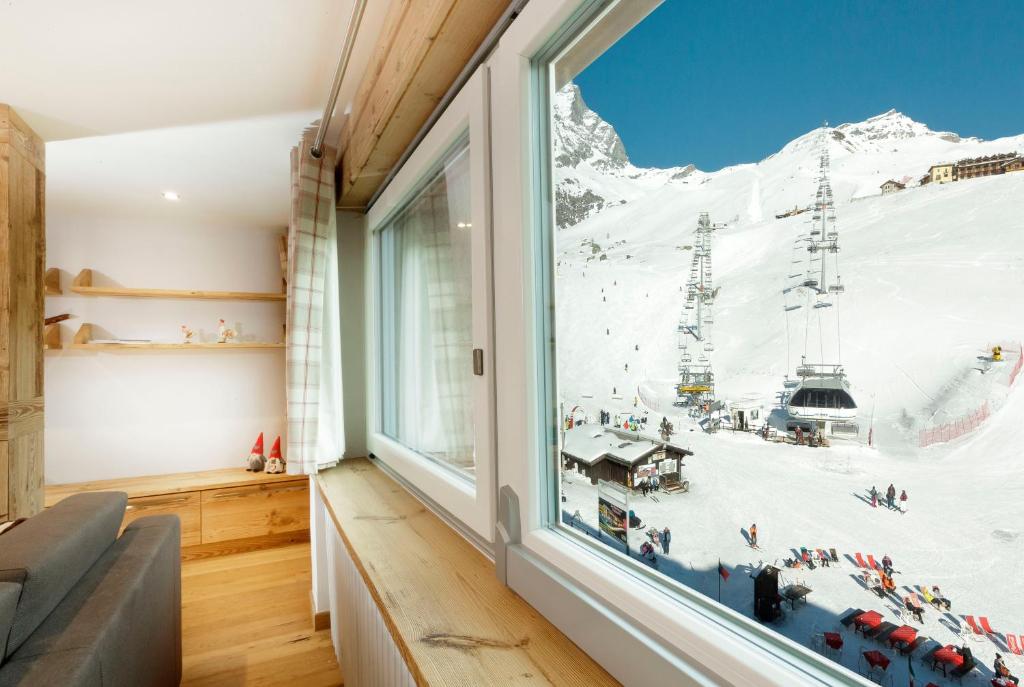 a room with a window with a mountain view at Maison Rêve Blanc - Panoramic Ski in - Ski out in Breuil-Cervinia