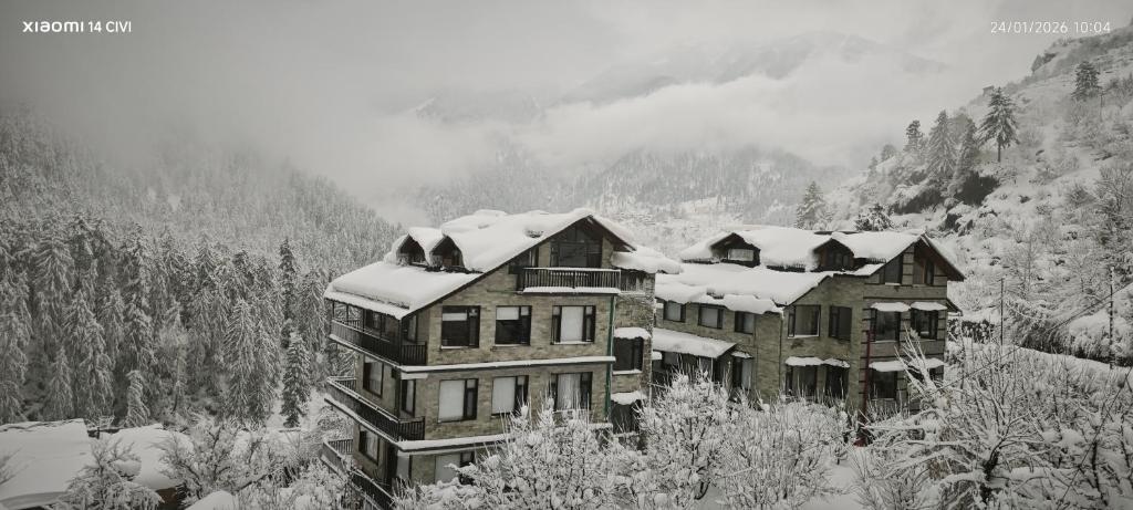 a large house with snow on top of it at Manali Se - Your Home in the Pines in Jagatsukh