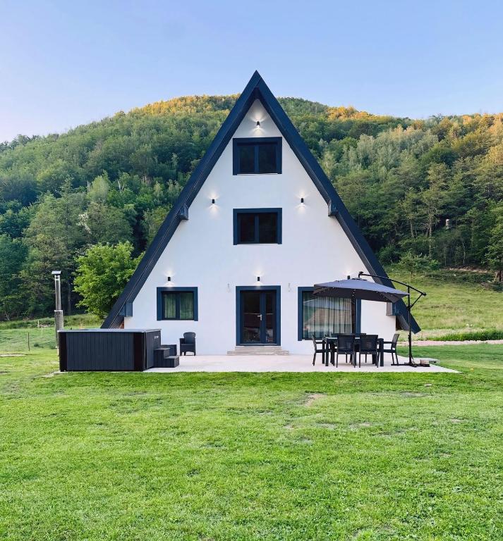 a large white house with a table in a field at Sunny Hill Cab in Bulz