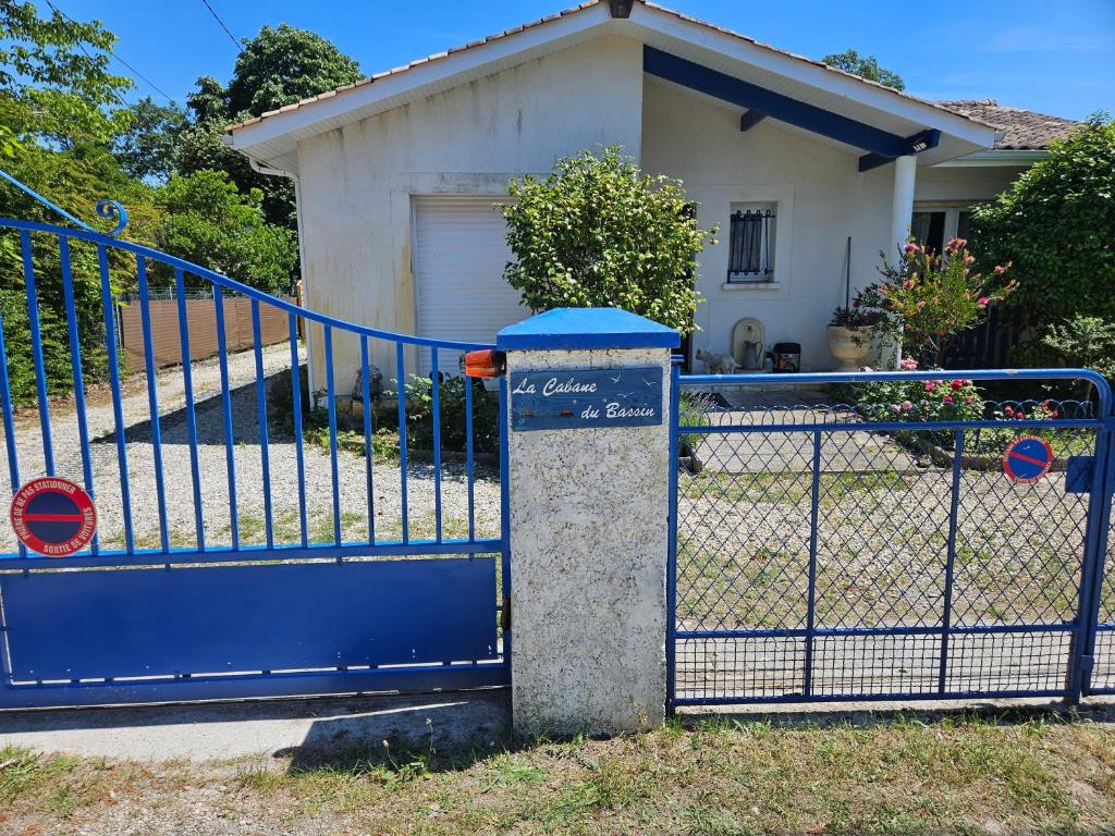 a blue gate in front of a house at La Cabane du Bassin in Lanton