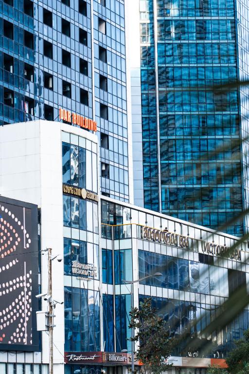 a tall glass building with a sign on it at Season Suite Apart-Hotel in Batumi