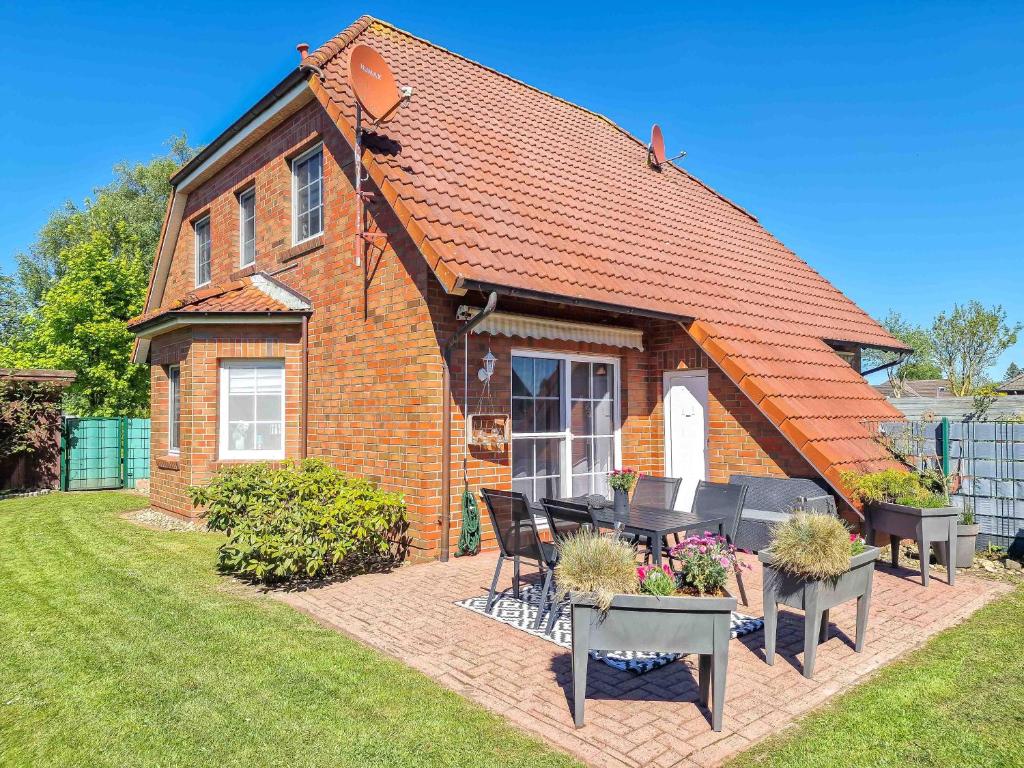 a brick house with a table and chairs in a yard at Wolles Sonnenhaus in Wirdum