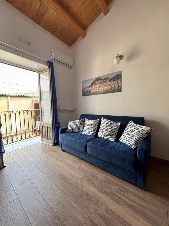 a blue couch in a living room with a balcony at Veterani House 33 in Cefalù