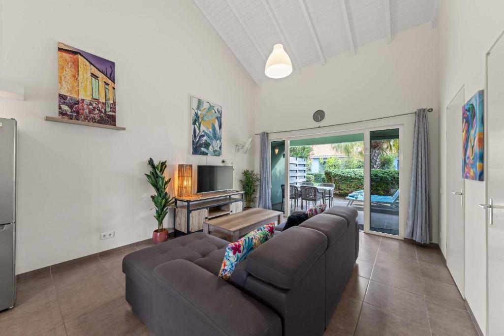 a living room with a couch and a television at Casa Verde - Blije Rust I in Dorp Sint Michiel