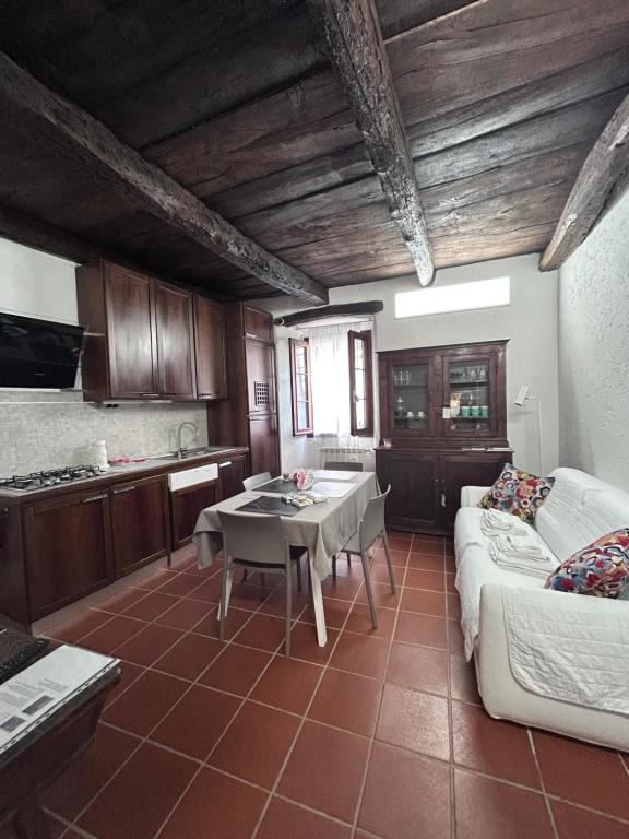 a kitchen and living room with a table and a couch at Il Sasso appartamento in Orta San Giulio