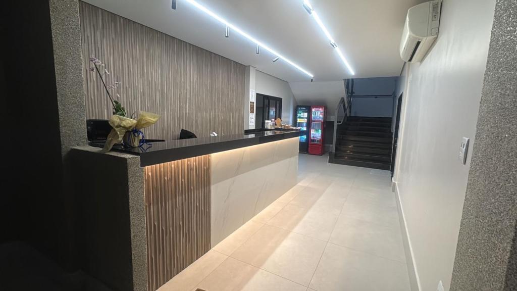 a large kitchen with a counter and a hallway at Carrijo Hotel in Marília