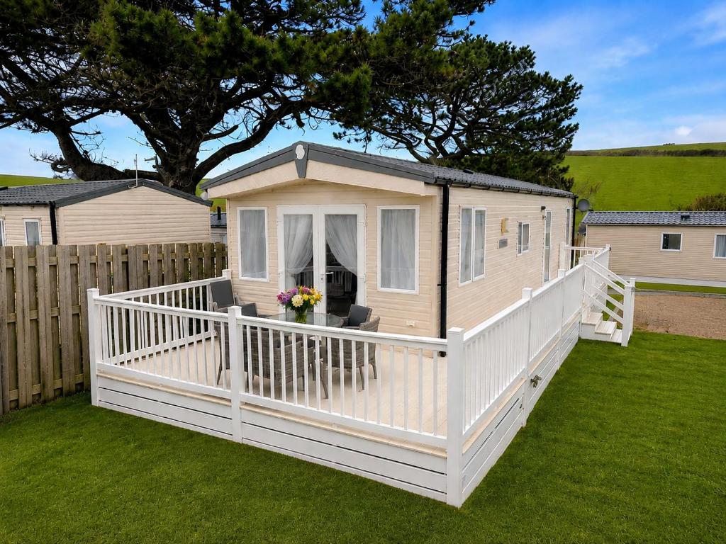 a tiny house with a porch and a fence at 11 Meadow View in Newquay