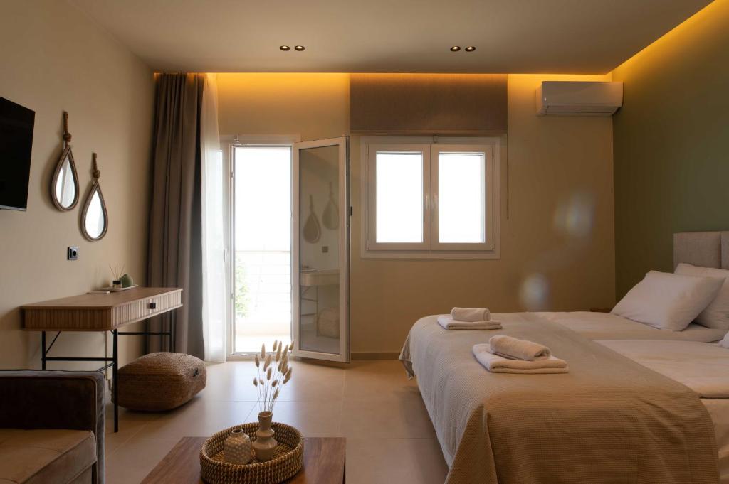 a bedroom with two beds and a desk and a window at Maistrali Luxury Living in Ouranoupoli
