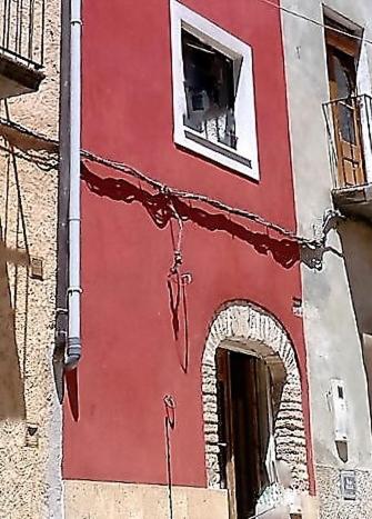 ein rotes Gebäude mit einem Fenster und einem Torbogen in der Unterkunft CALANURI in García
