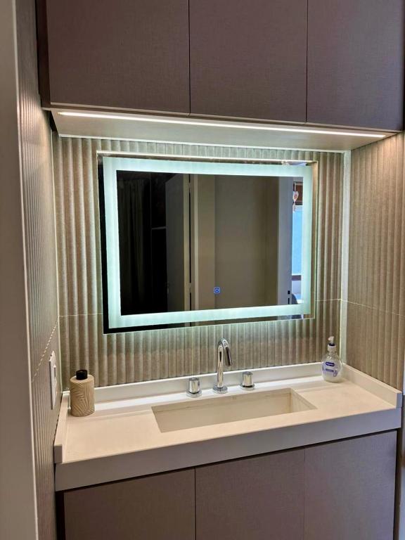 a bathroom sink with a large mirror above it at Vcp urban suites in Villa Carlos Paz
