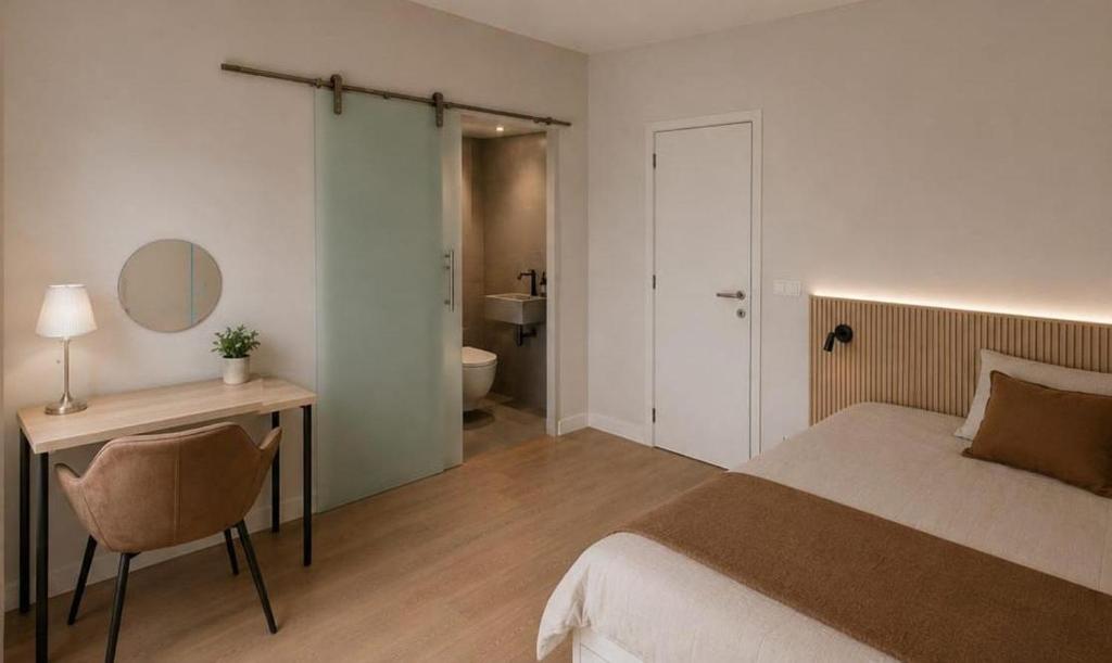 a bedroom with a bed and a desk and a bathroom at L' Gante in Ghent