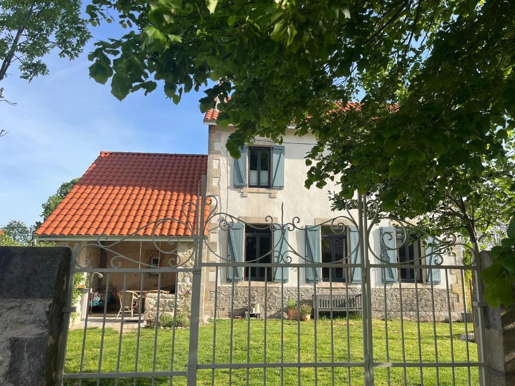 ein Haus mit einem Zaun davor in der Unterkunft L'école perdue in Saint-Martin-dʼOllières