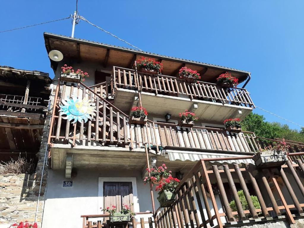 a building with balconies and flower boxes on it at Nido Paradiso Nido, Balcone panoramico sulla Valle Soana in Ingria