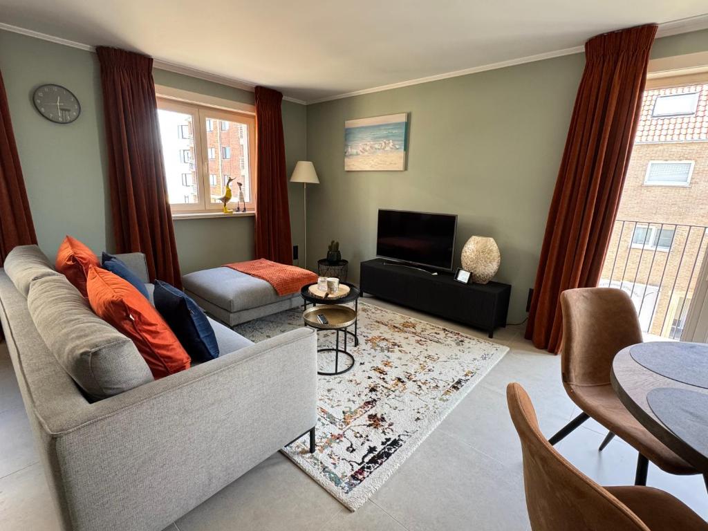 a living room with a couch and a television at Relax & Sea in Ostend