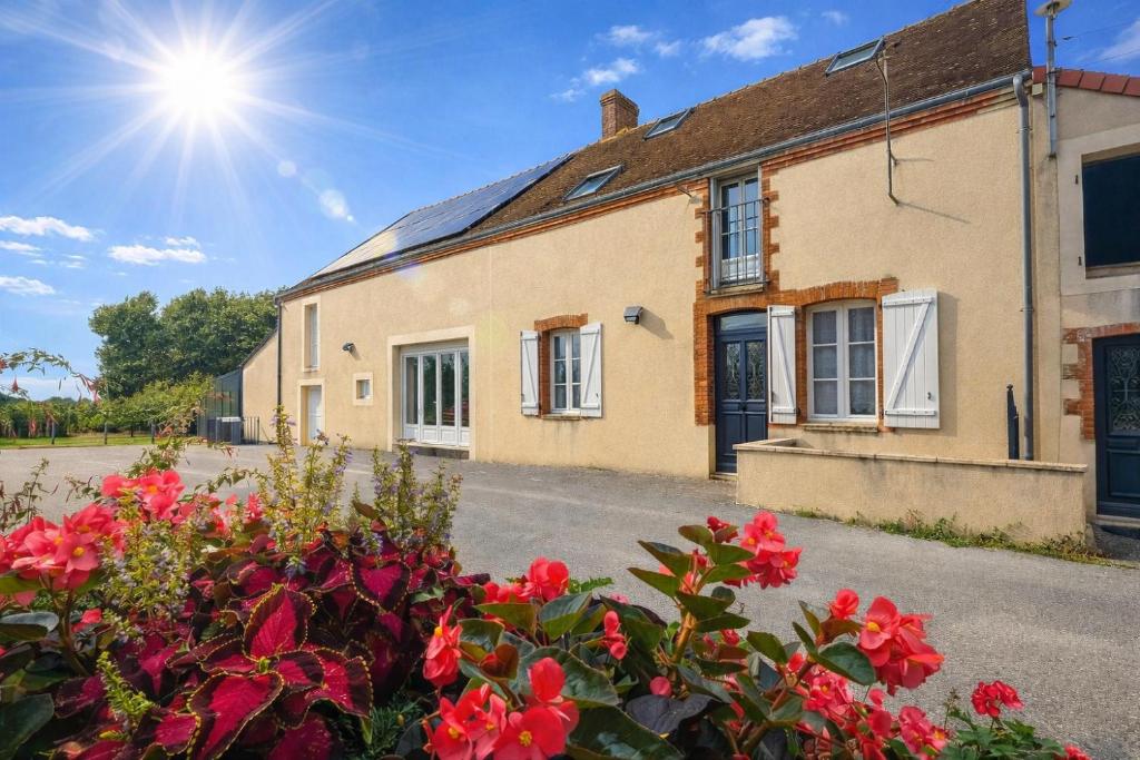 an old house with flowers in front of it at Gîte Les Chaumes in Orsennes