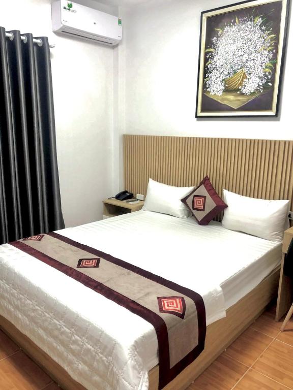 a bedroom with a bed and a picture on the wall at Hotel Vân Anh in Hanoi