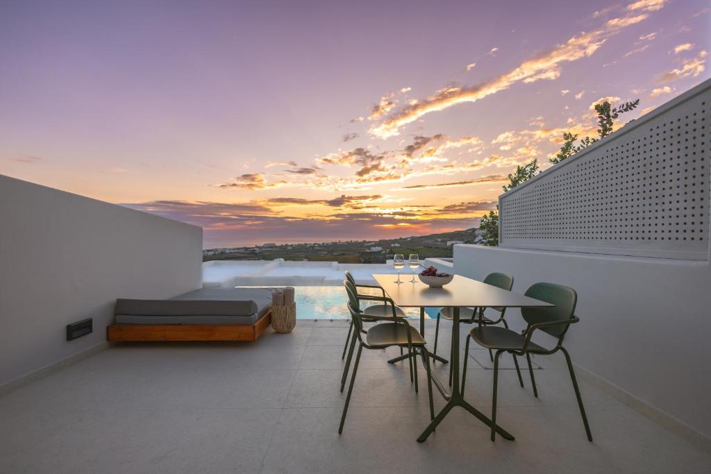 a balcony with a table and chairs and a bed at Evira Suites in Pyrgos